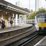 a yellow and white train pulling into a train station