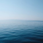 body of water under blue and white sky at daytime