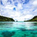 body of water between mountain during daytime