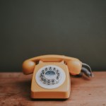 brown rotary dial telephone in gray painted room