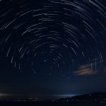 a star trail over a body of water