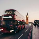 a red double decker bus driving down a street