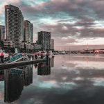 city skyline across body of water during night time